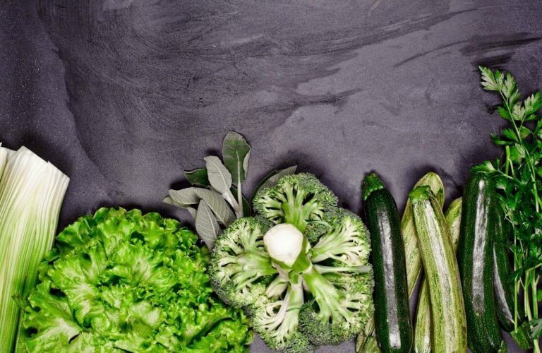 Broccoli, celery, and celery stalks laid out on