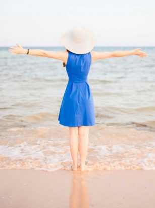 Young woman in blue dress at the beach