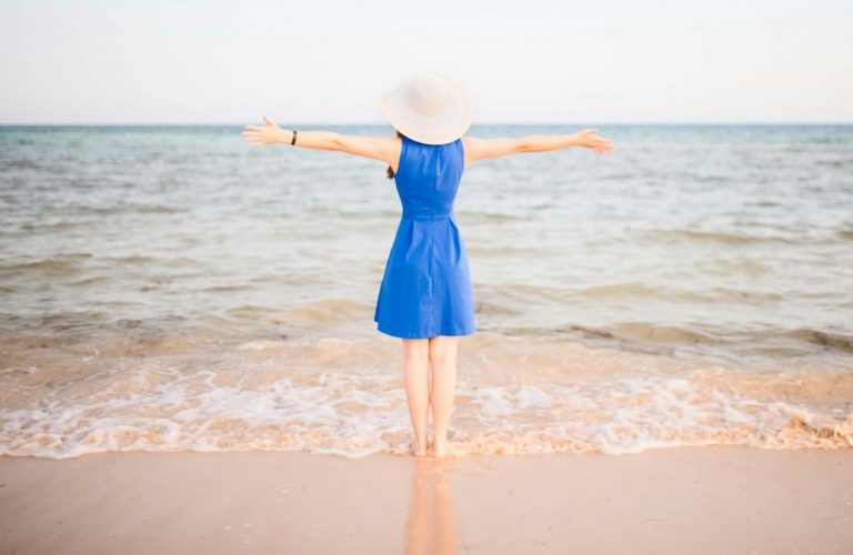 Young woman in blue dress at the beach